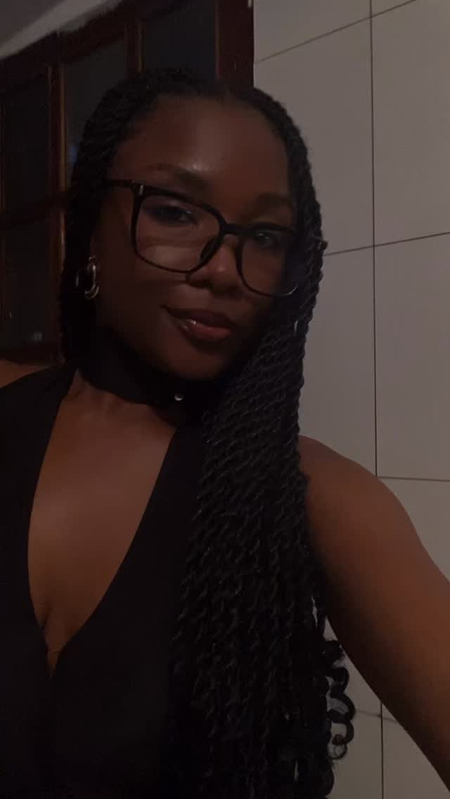 Georgina Tomás de óculos e tranças, com um sorriso confiante