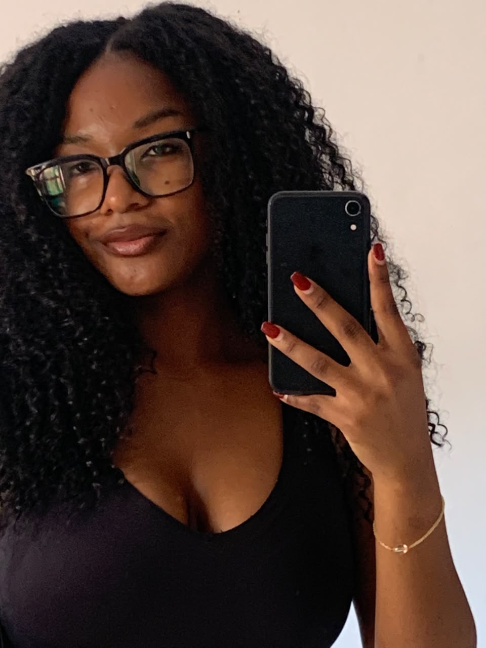 Georgina Tomás de óculos e cabelo encaracolado, selfie no espelho